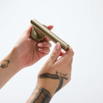 Notorious Door Handle Held in Hand in Brushed Gold