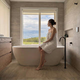 A lifestyle photo showing the antique brass floor spout over a bath overlooking the garden. 