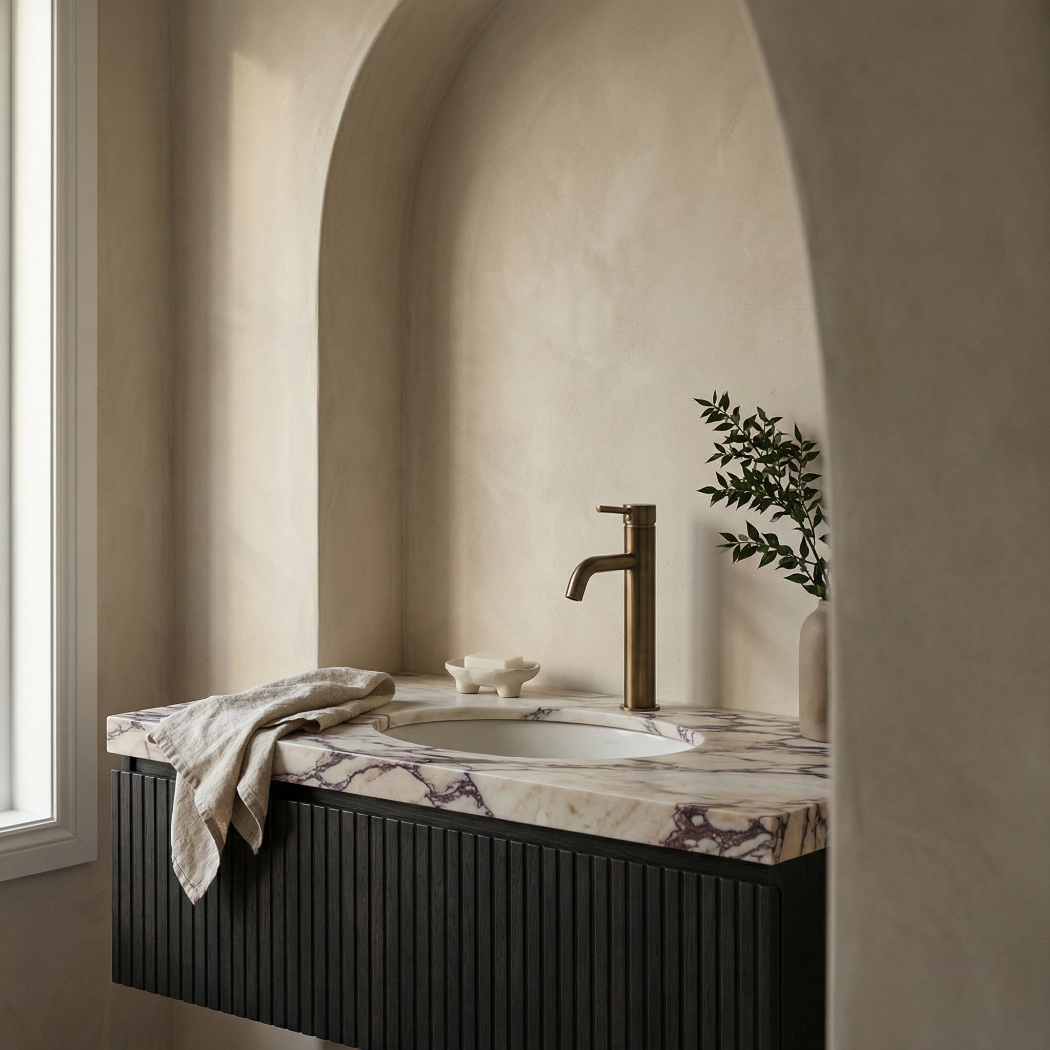 Notorious Tall Basin Mixer Antique Brass shown in a modern bathroom setting with a marble vanity top