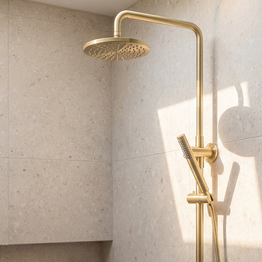 Brushed Gold shower head and handheld in a bathroom with tiled walls.