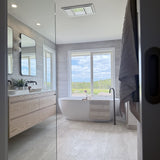 Modern bathroom with freestanding bathtub, large mirror, and window view