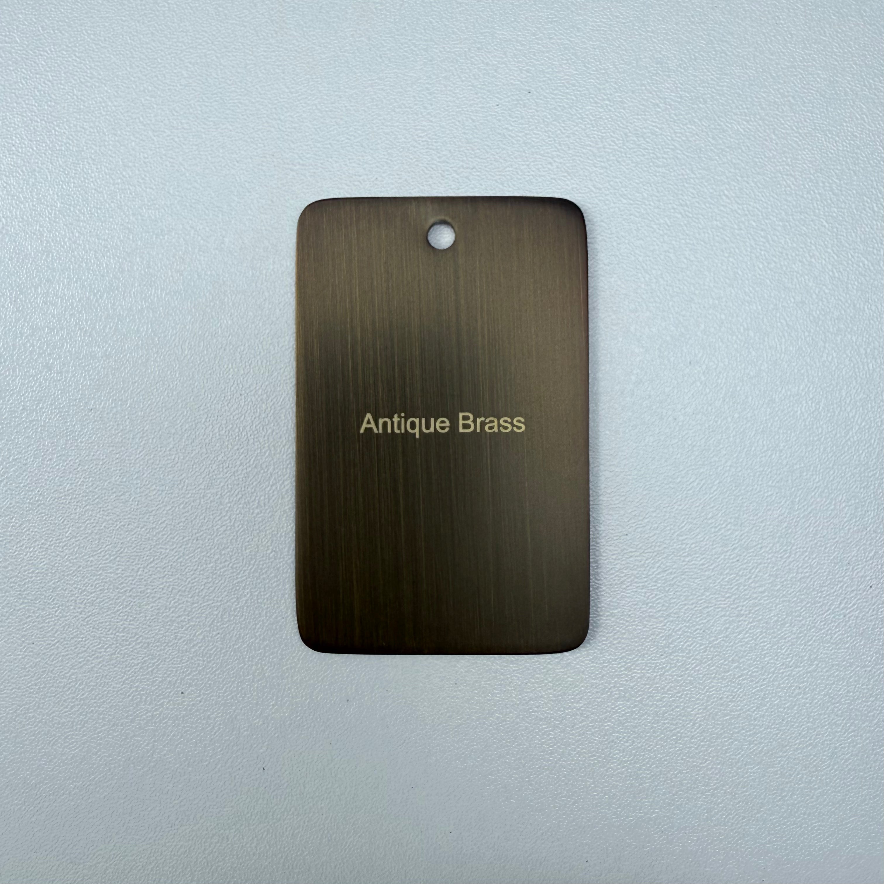 Antique brass sample disc on a white background