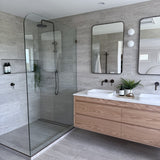 Antique Brass tapware in a modern bathroom with glass shower enclosure, wooden vanity, and large mirror.