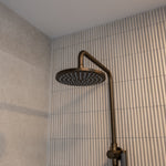 Antique brass twin shower with diverter on a tiled bathroom wall