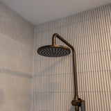 Antique brass twin shower with diverter on a tiled bathroom wall