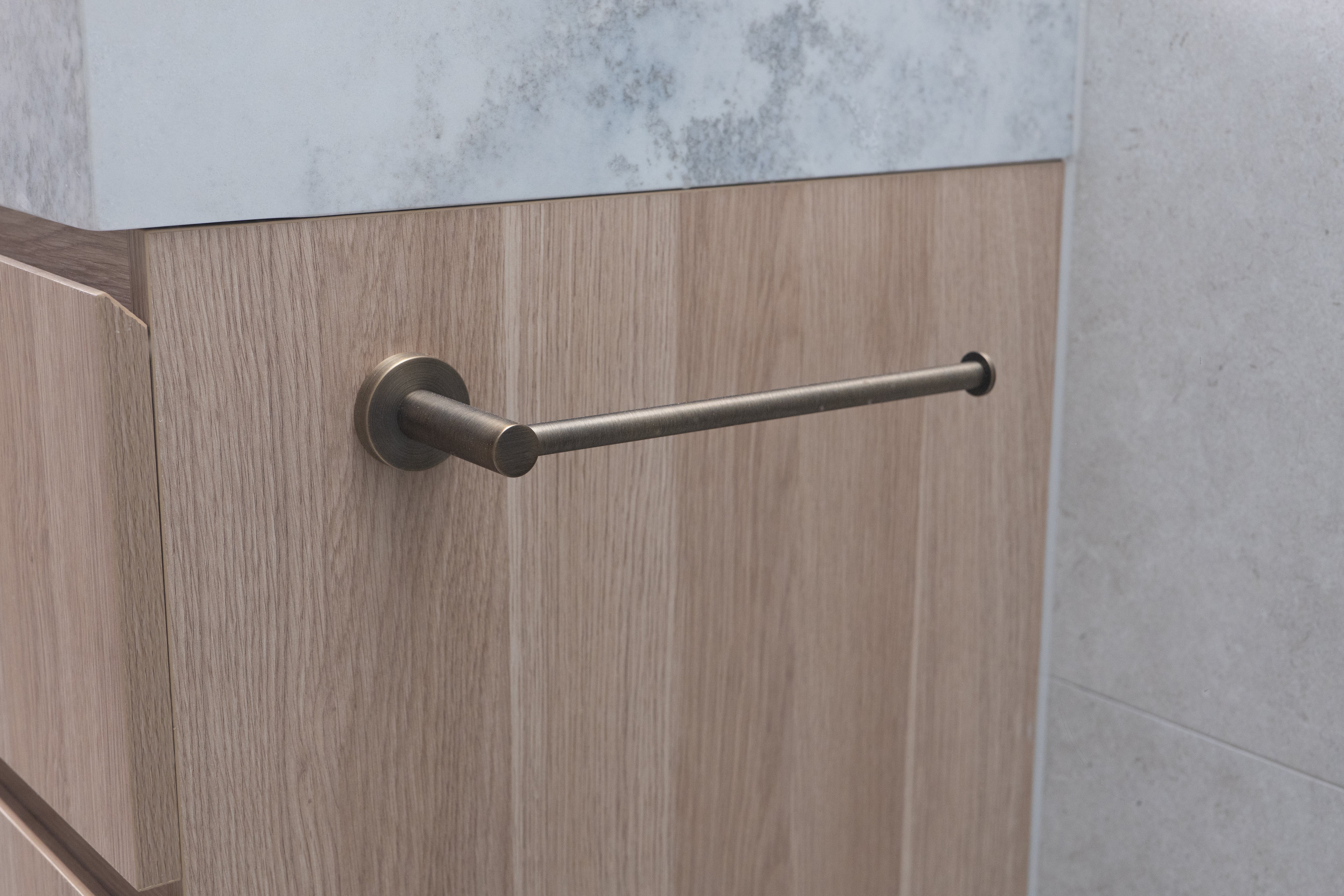 antique brass hand towel holder rail on a oak timber vanity background