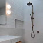 Antique Brass Twin Round Combination Shower Rail with Diverter and Hand Held wand on a grey tile background