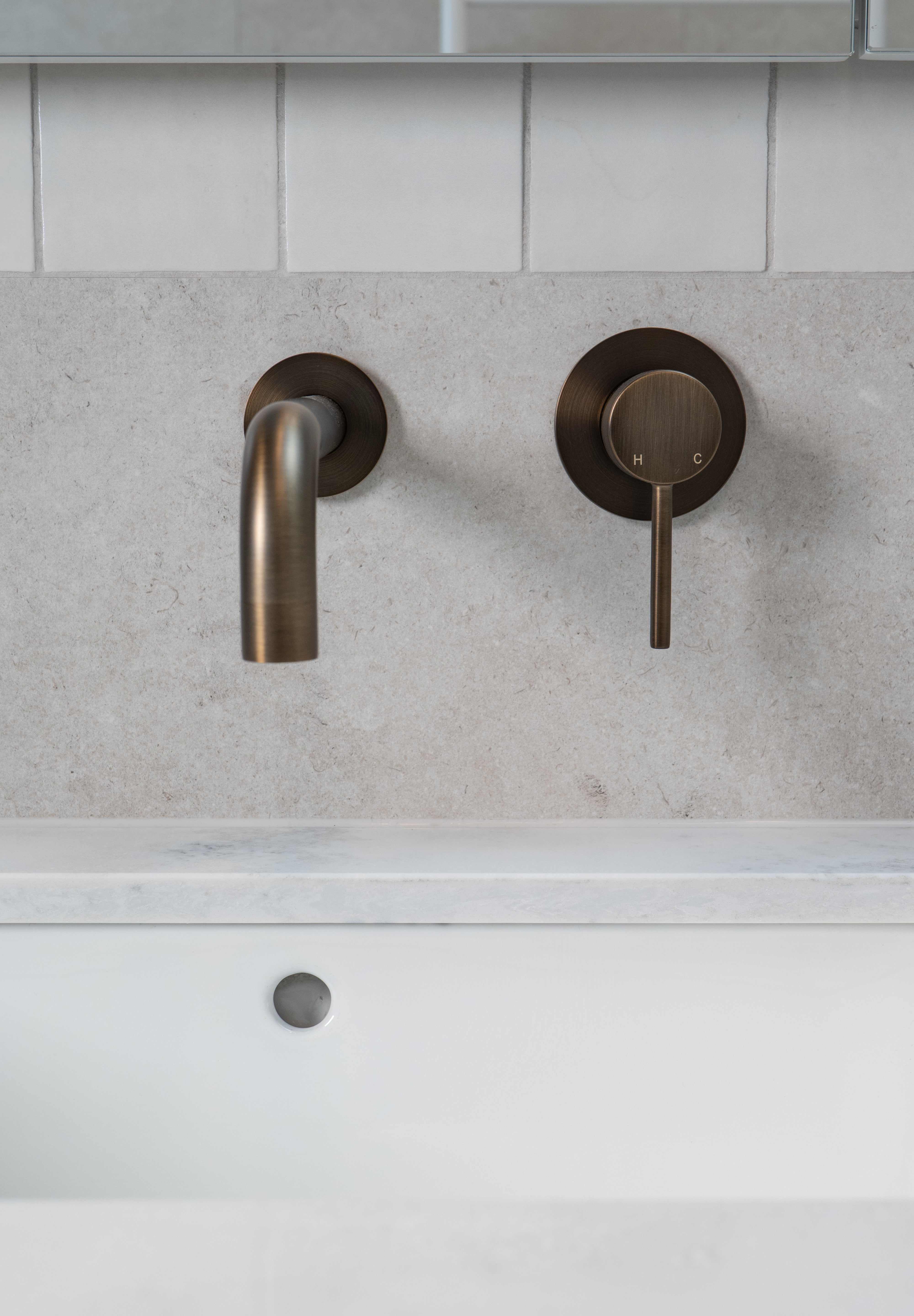 antique brass wall mounted over vanity wall mixer and spout on grey and white tile background