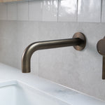 Antique Brass tap wall spout and mixer on grey tile marble bench and white tile splash back