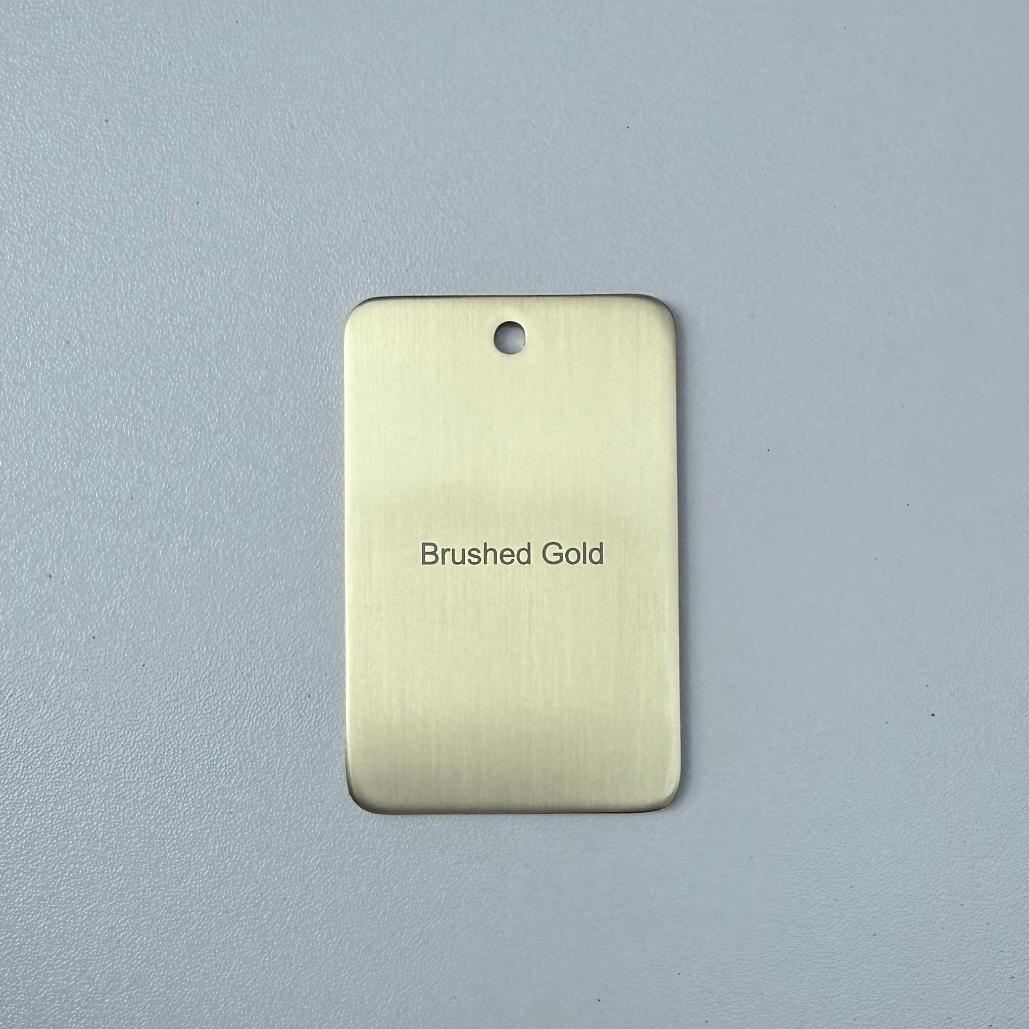 Brushed gold sample disc on a white background