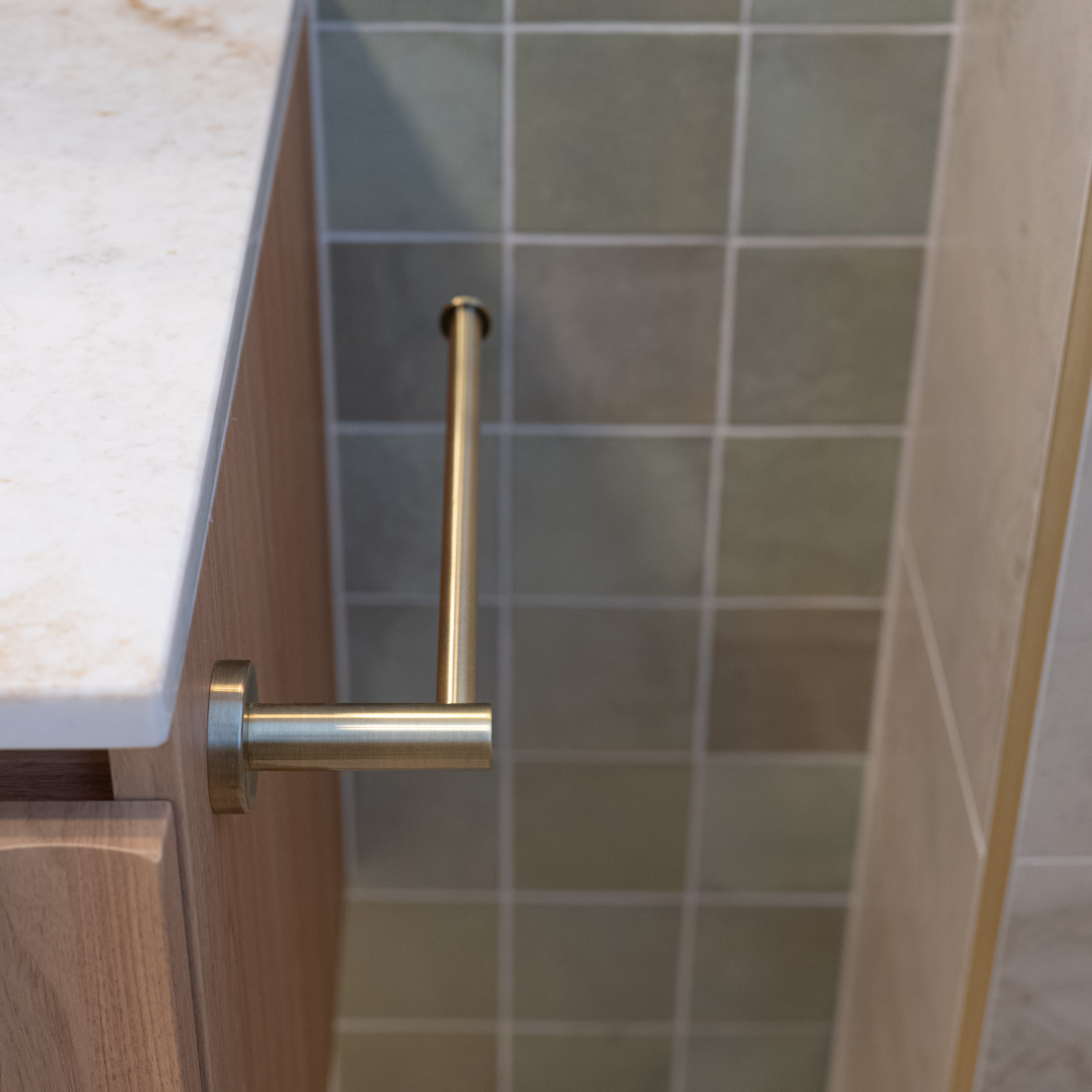 Bathroom cabinet with brushed holder towel holder against tiled wall