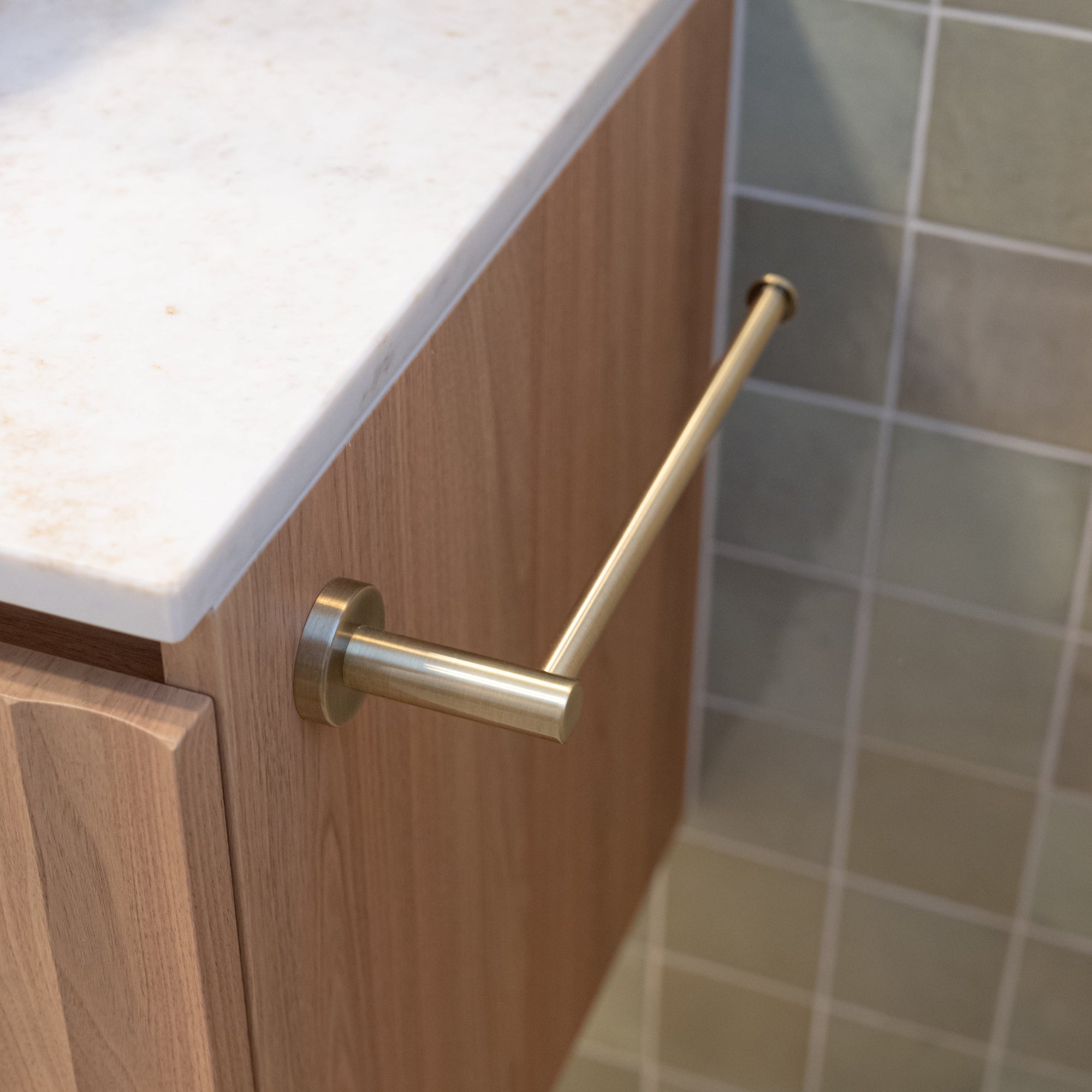 Bathroom cabinet with brushed holder towel holder against tiled wall