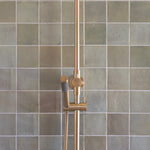 brushed gold twin round combination shower rail with diverter on a green feature tile background