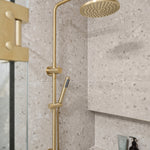 brushed gold twin round combination shower rail with diverter on a terazzo tile background