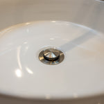Brushed nickel pop up waste with no overflow in a white basin