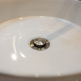Brushed nickel pop up waste with no overflow in a white basin