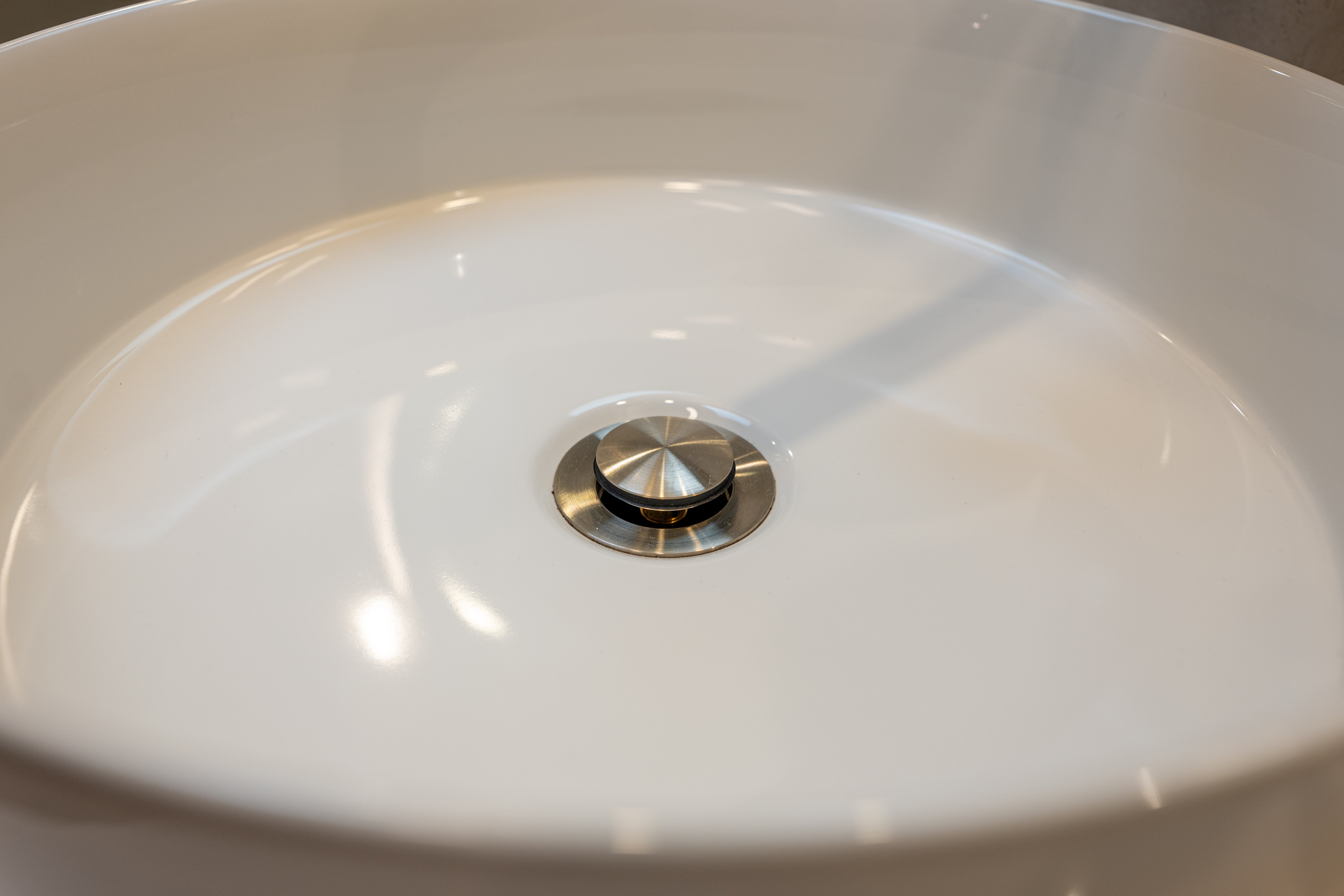 Brushed nickel pop up waste with no overflow in a white basin