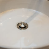 Brushed nickel pop up waste with no overflow in a white basin