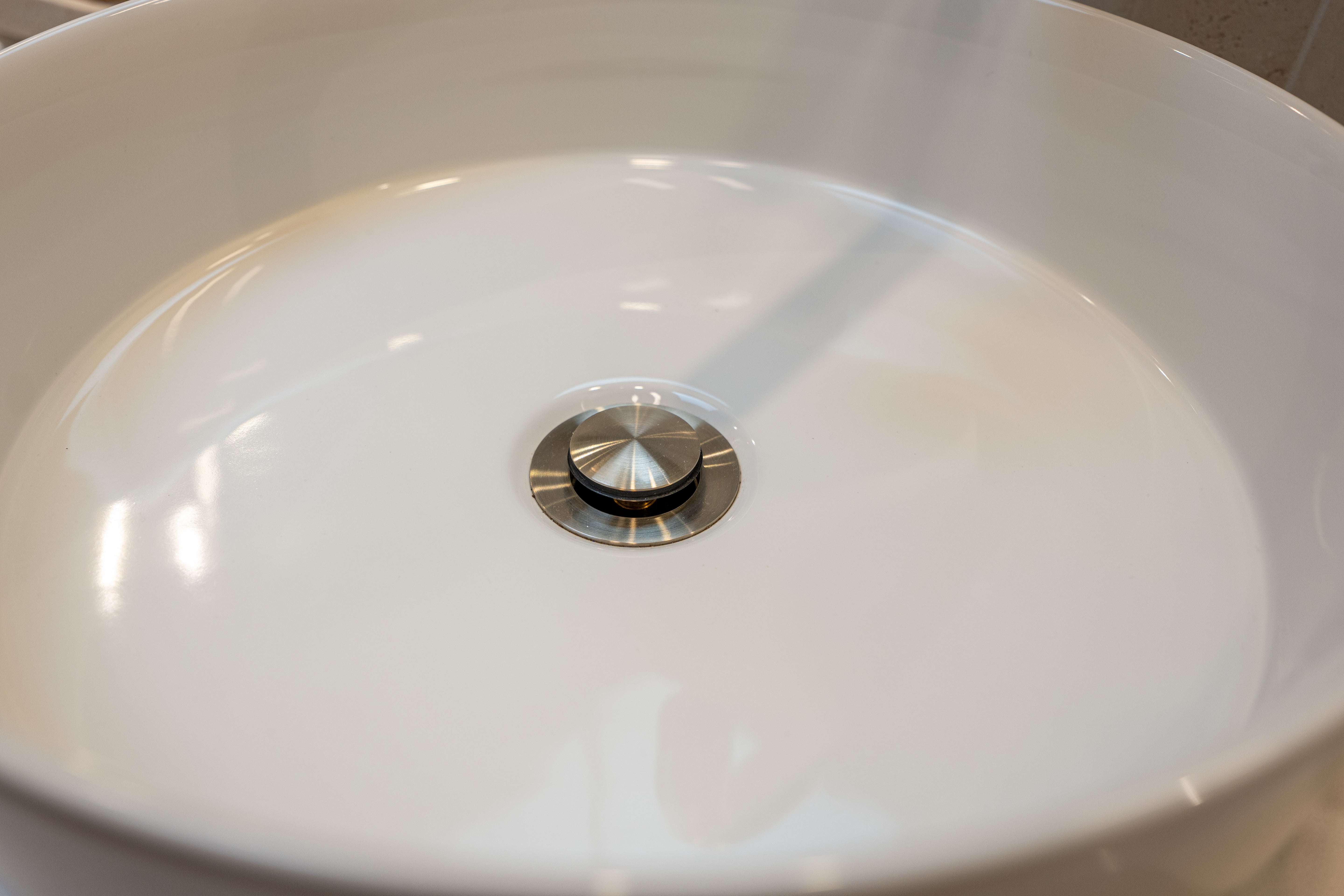 Brushed nickel pop up waste with no overflow in a white basin