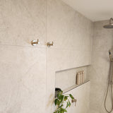 Shower area with tiled walls, a brushed nickel twin shower and diverter, brushed nickel robe hooks with a niche.