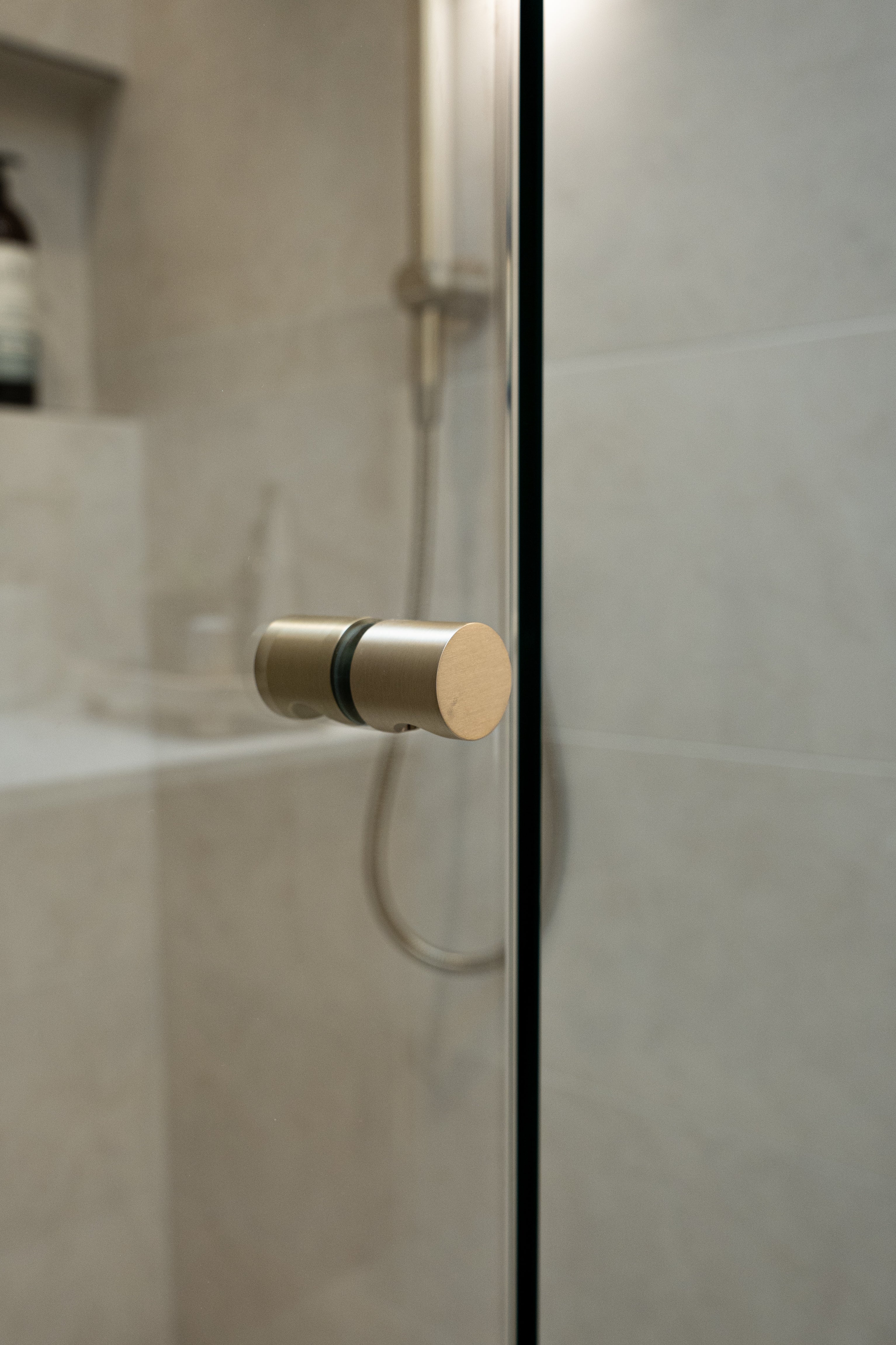 Brushed nickel shower door handle on a shower glass door