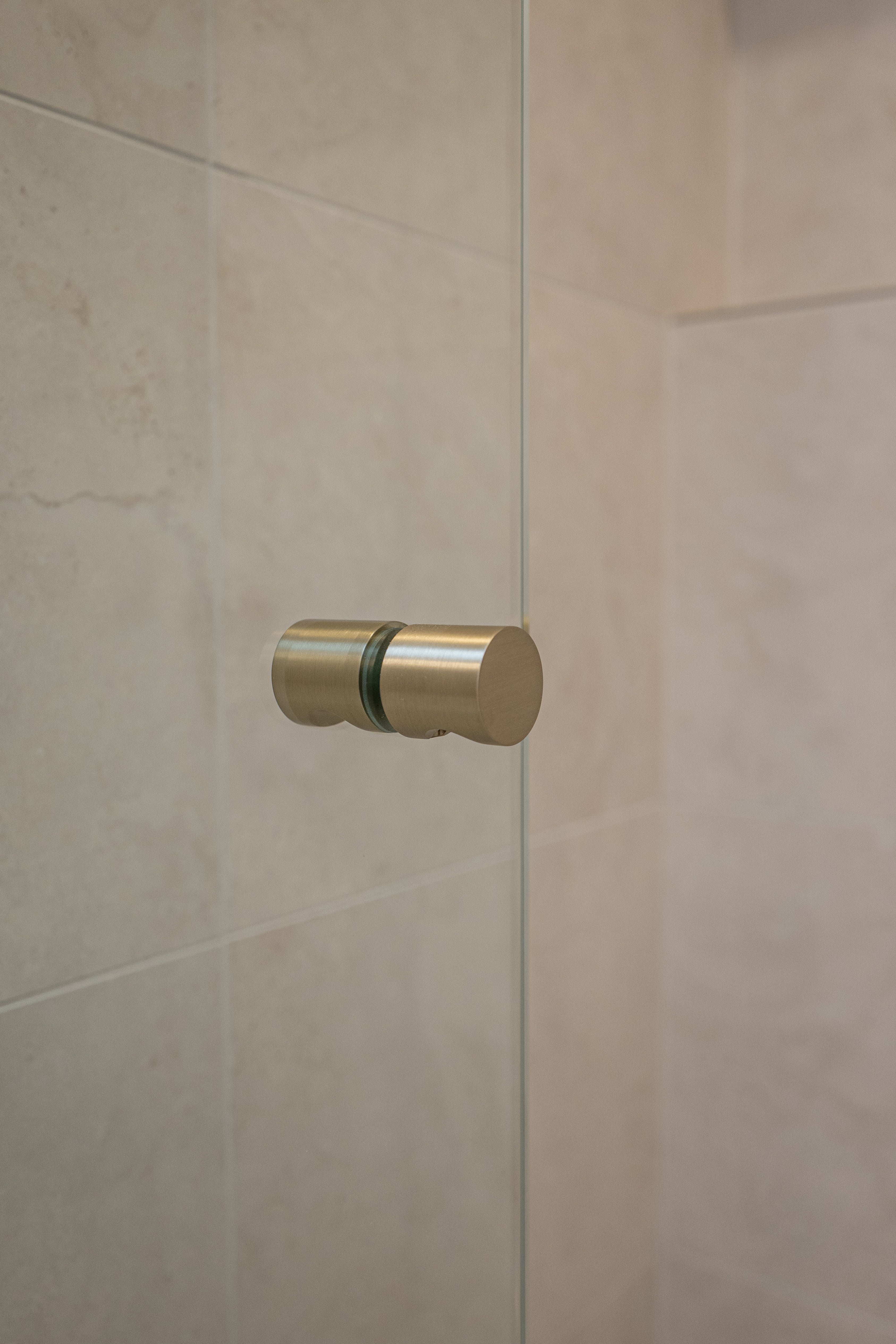 Brushed nickel shower door handle on a shower glass door