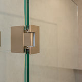 Brushed nickel shower door hinge on a glass shower door with tiled wall background.