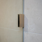 Brushed nickel shower glass clamp on a tiled wall.