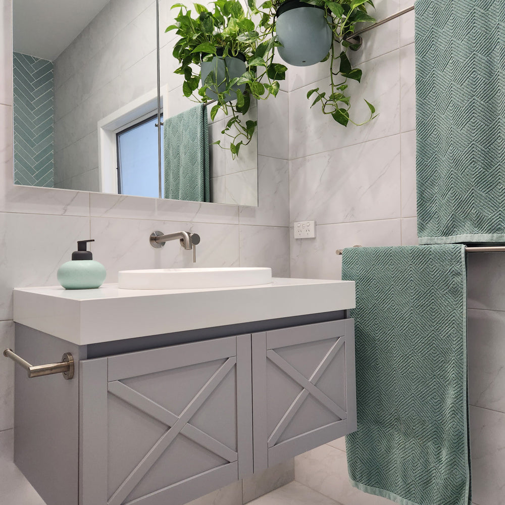 a brushed nickel towel holder mounted on a grey vanity with white stone top