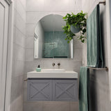 a set of brushed nickel towel rails in a bathroom interior with a sink, mirror, and plant