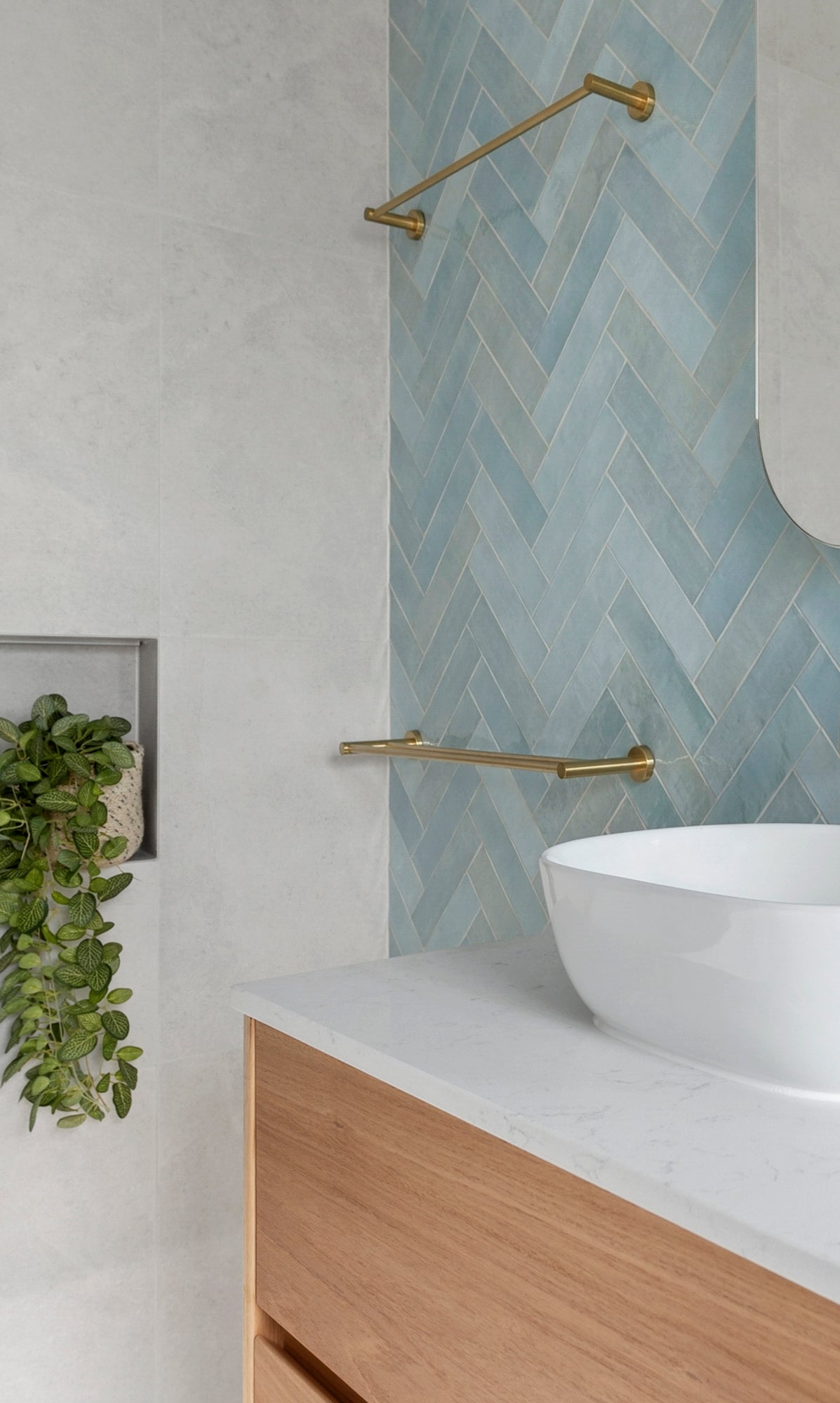 brushed gold single towel rail in a bathroom wall mounted to a blue tiled wall 