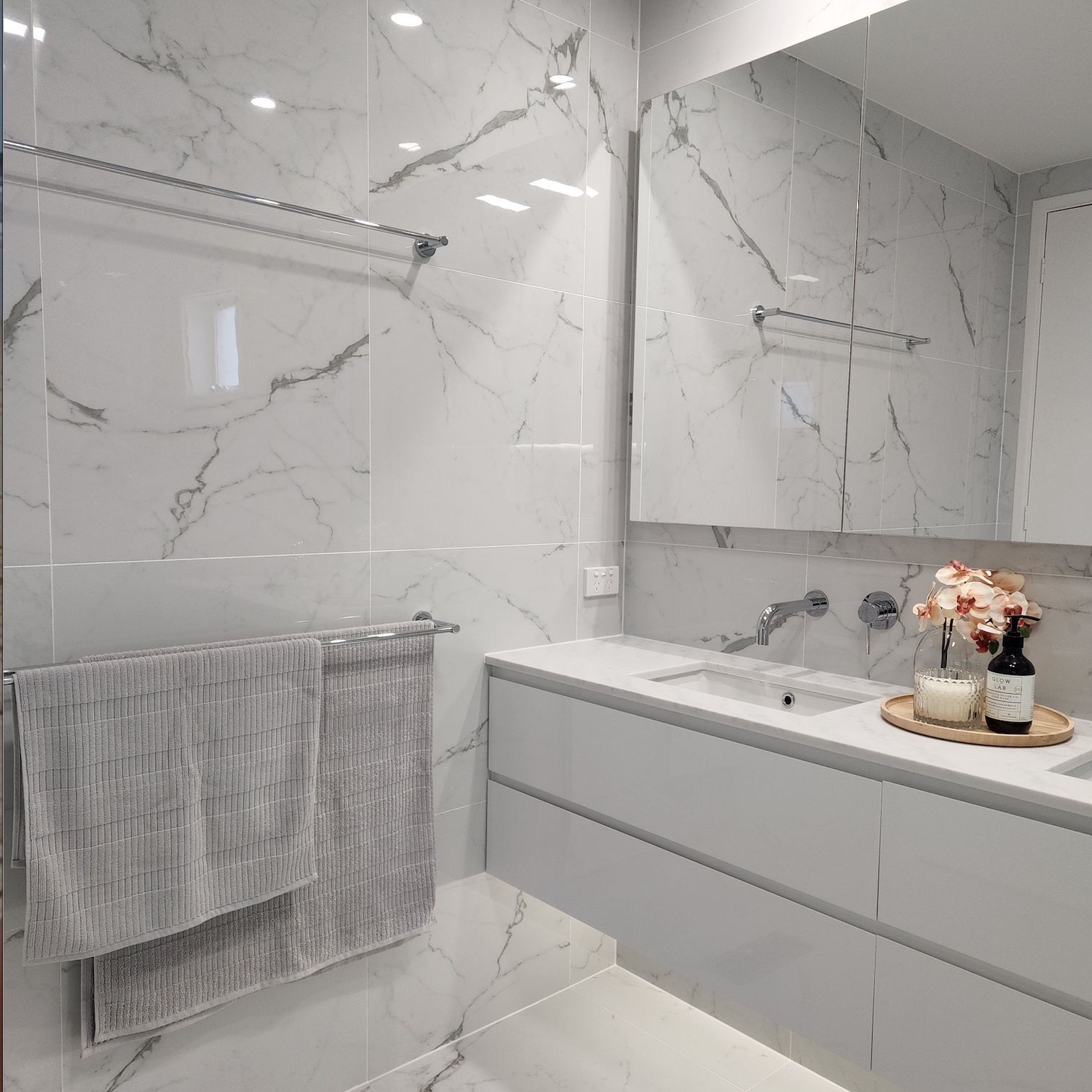 a chrome double towel rail on a marble wall background