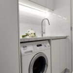 Modern laundry with white cabinets, white splashback and chrome pull-out kitchen/laundry mixer