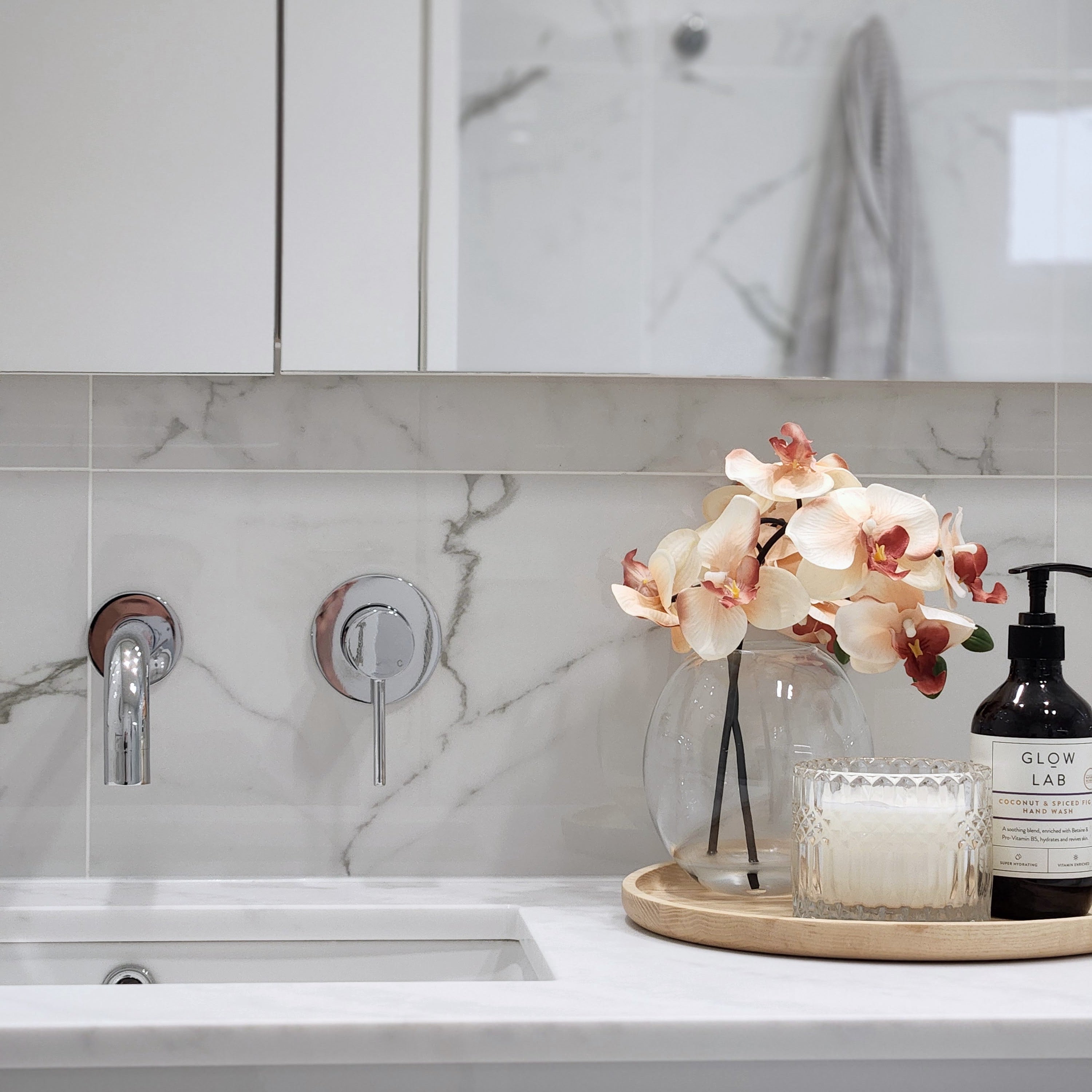  chrome wall spout and mixer on a marble tile background