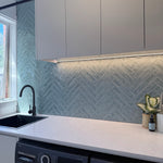 Modern Laundry with white cabinets, a chevron-patterned backsplash, and with a gun metal kitchen/laundry mixer