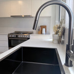 Modern kitchen with a gun metal sink and gun metal pull out kitchen/laundry mixer.