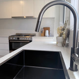 Modern kitchen with a gun metal sink and gun metal pull out kitchen/laundry mixer.