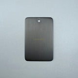 Gun metal sample disc on a grey background