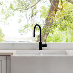a matt black kitchen laundry pull out mixer tap in a bright kitchen setting