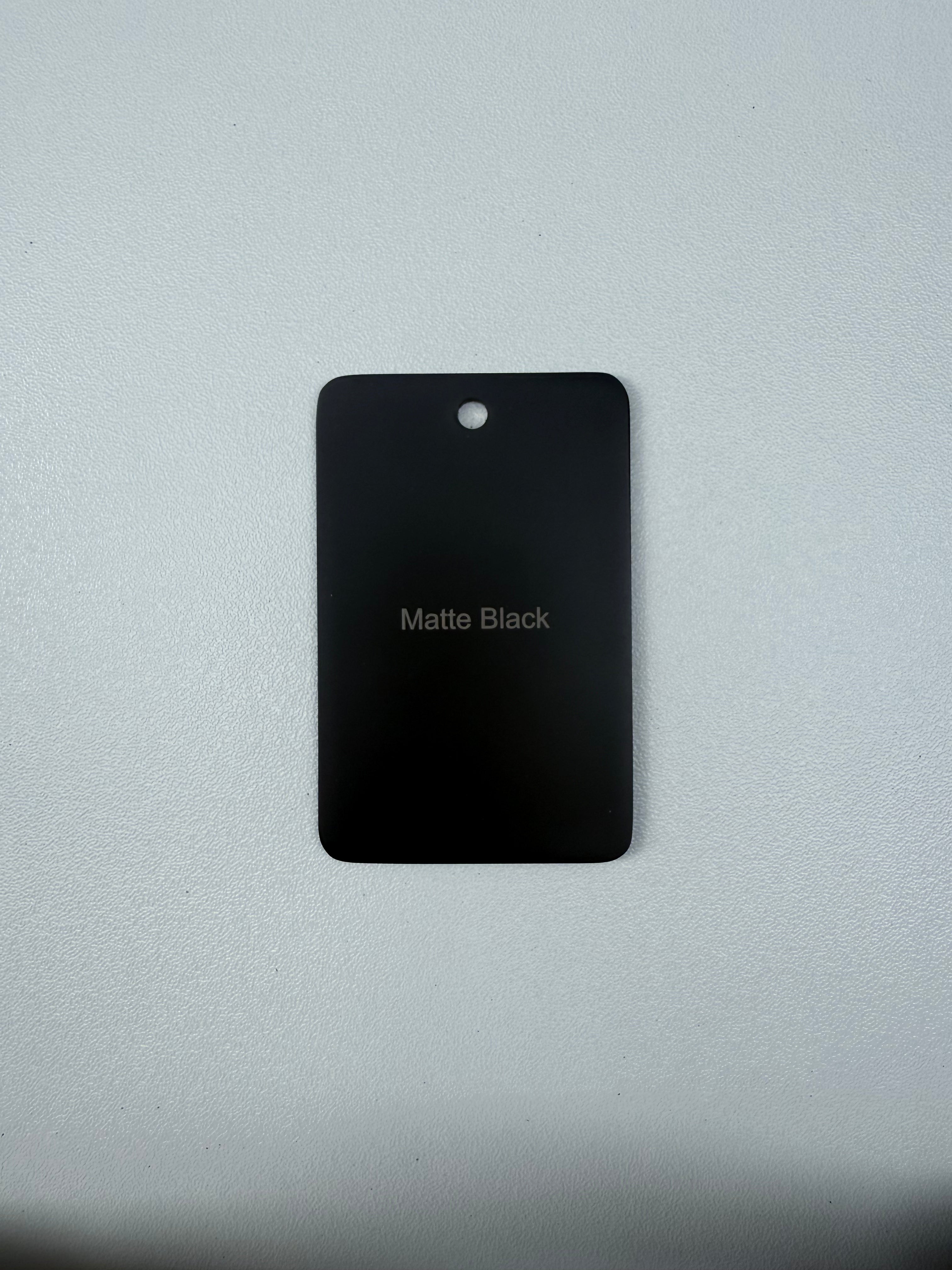 Matt Black sample disc on a grey background