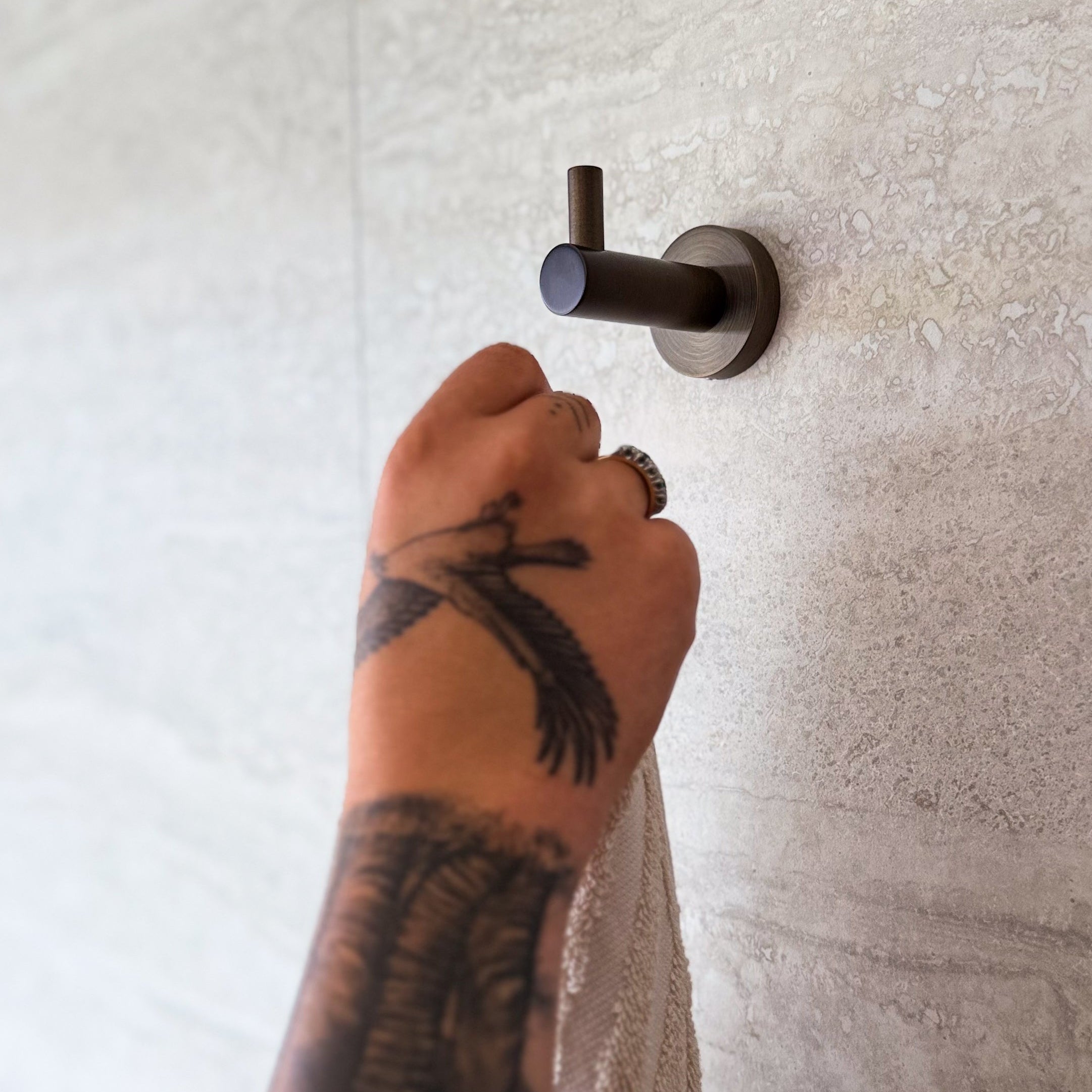 notorious collective robe hooks antique brass shown on neutral tiles.